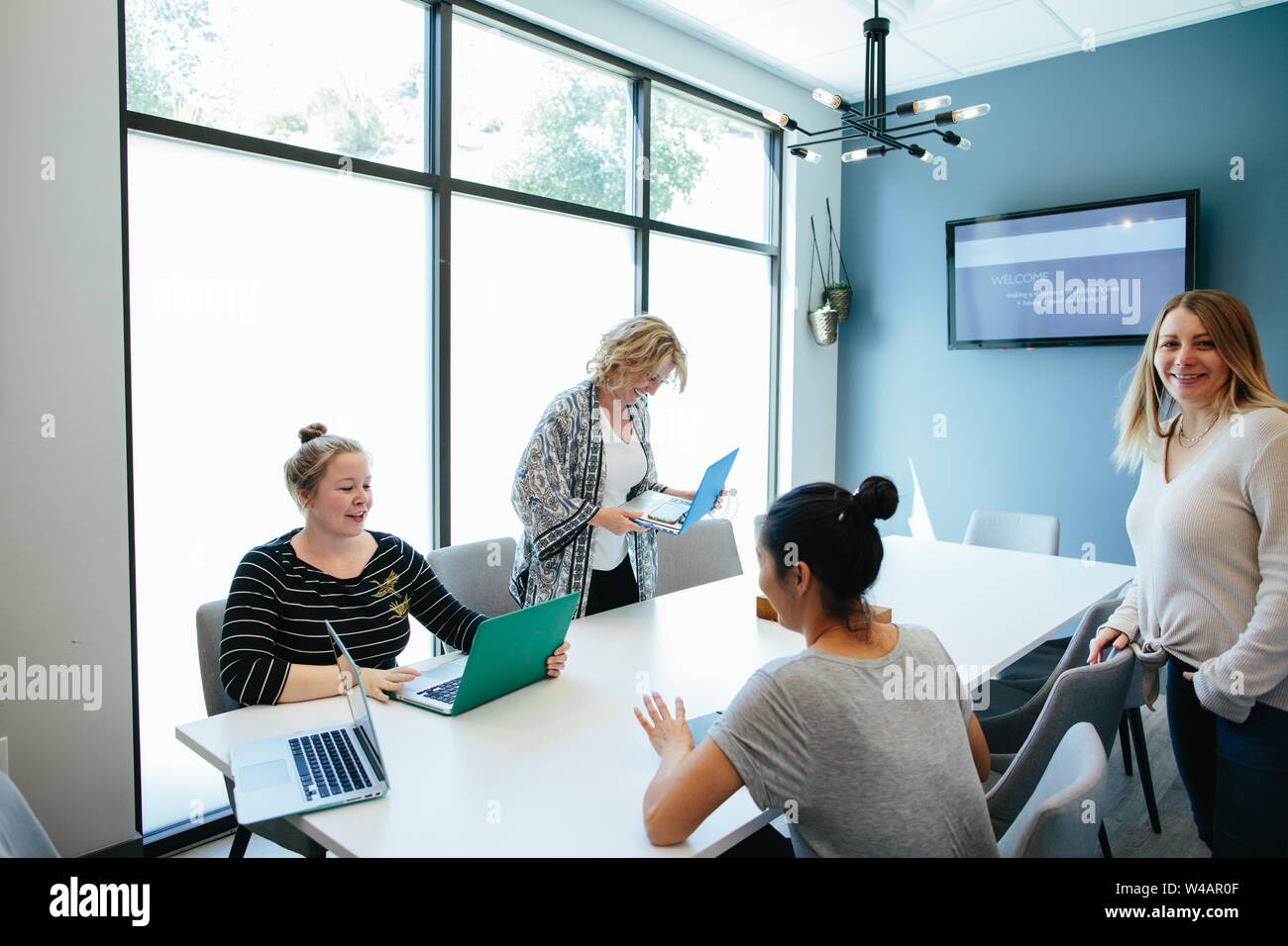 Women smiling wrap up their meeting in a conference room Stock Photo