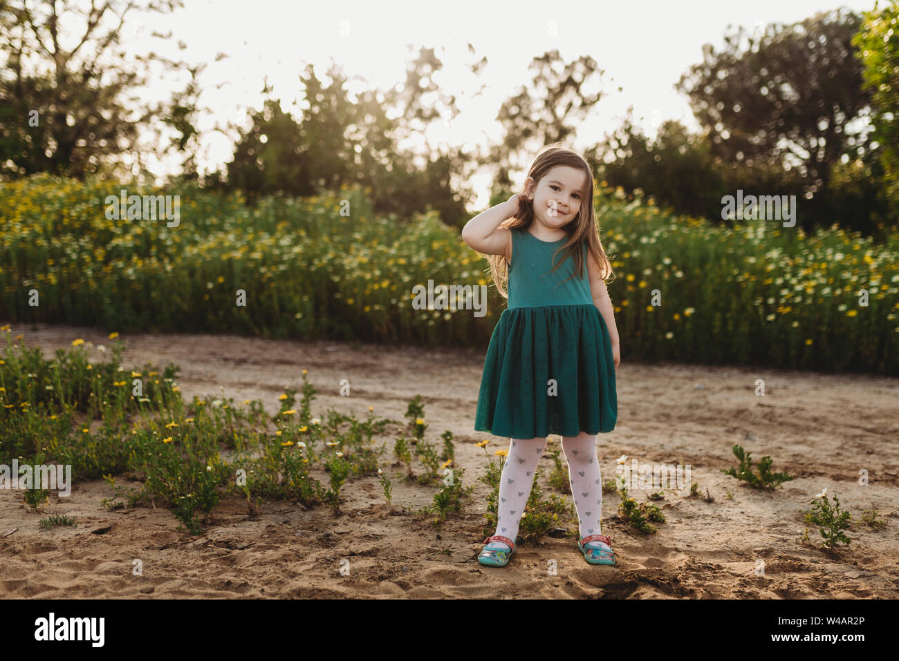 Portrait of little girl standing in field of flowers Stock Photo - Alamy