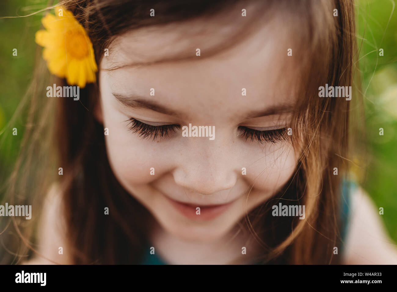 Close up portrait of little girl with eyes closed and smiling Stock Photo