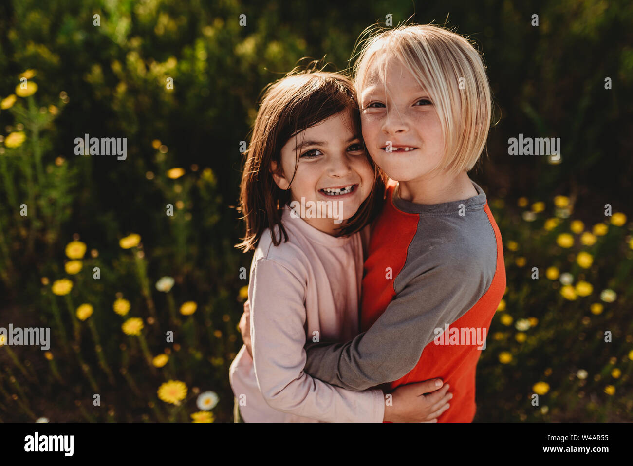 Portrait of school-aged children smiling at the camera in backlight Stock Photo