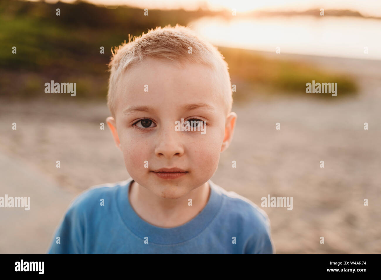 Backlit portrait of young boy looking at camera seriously Stock Photo