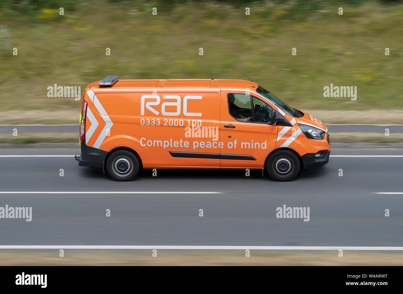An RAC breakdown recovery van travels along the A556 road in Alderley Edge, Cheshire, UK. Stock Photo