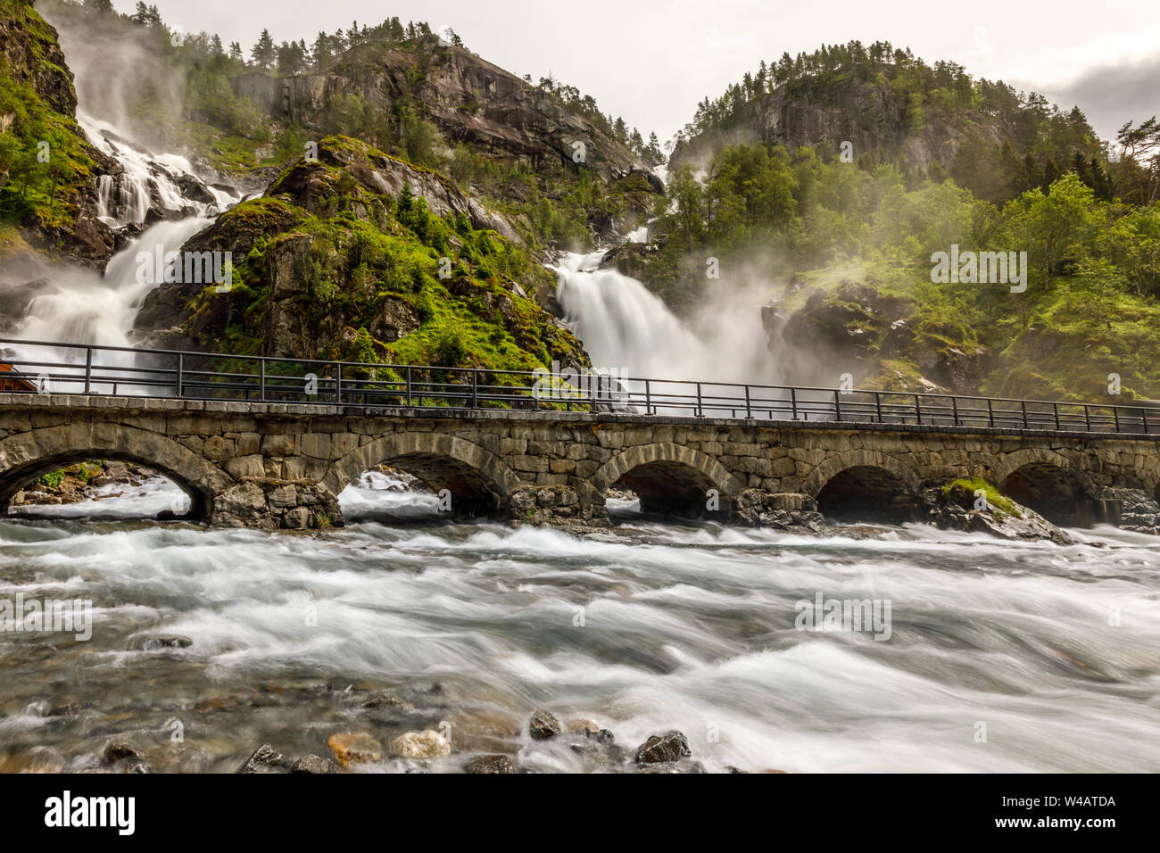 Latefoss twin waterfalls streams under the stone bridge archs, Odda, Hordaland county, Norway Stock Photo