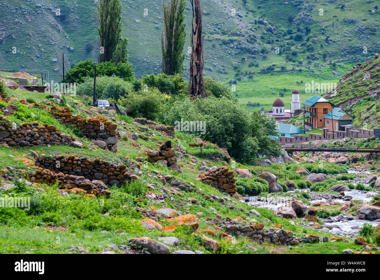 Green landscape of river in Caucasus mountains and small mosque Stock Photo