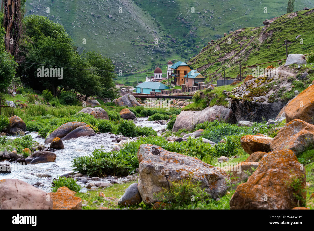 Green landscape of river in Caucasus mountains and small mosque Stock Photo