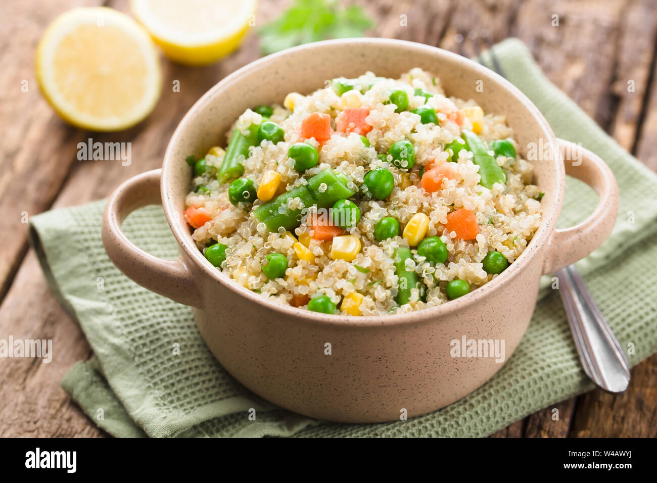 Fresh homemade cooked white quinoa with colorful vegetables (green peas