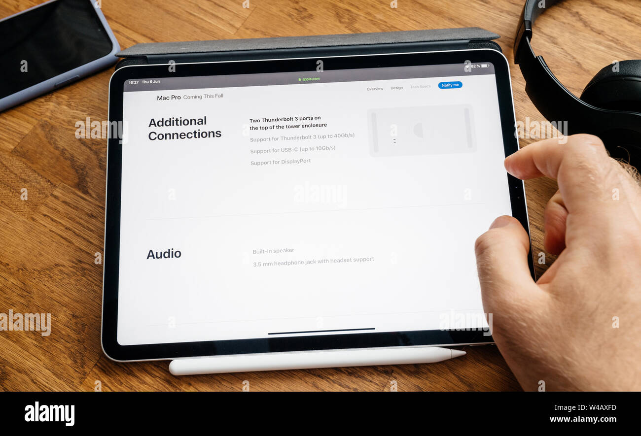 Paris, France - Jun 6, 2019: Man reading on Apple iPad Pro tablet about latest announcement of at Developers Conference (WWDC) - showing the Mac Pro workstation with audio and connections Stock Photo