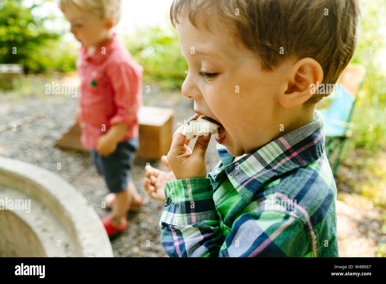 Closeup side view of a young boy eating a marshmallow smore Stock Photo