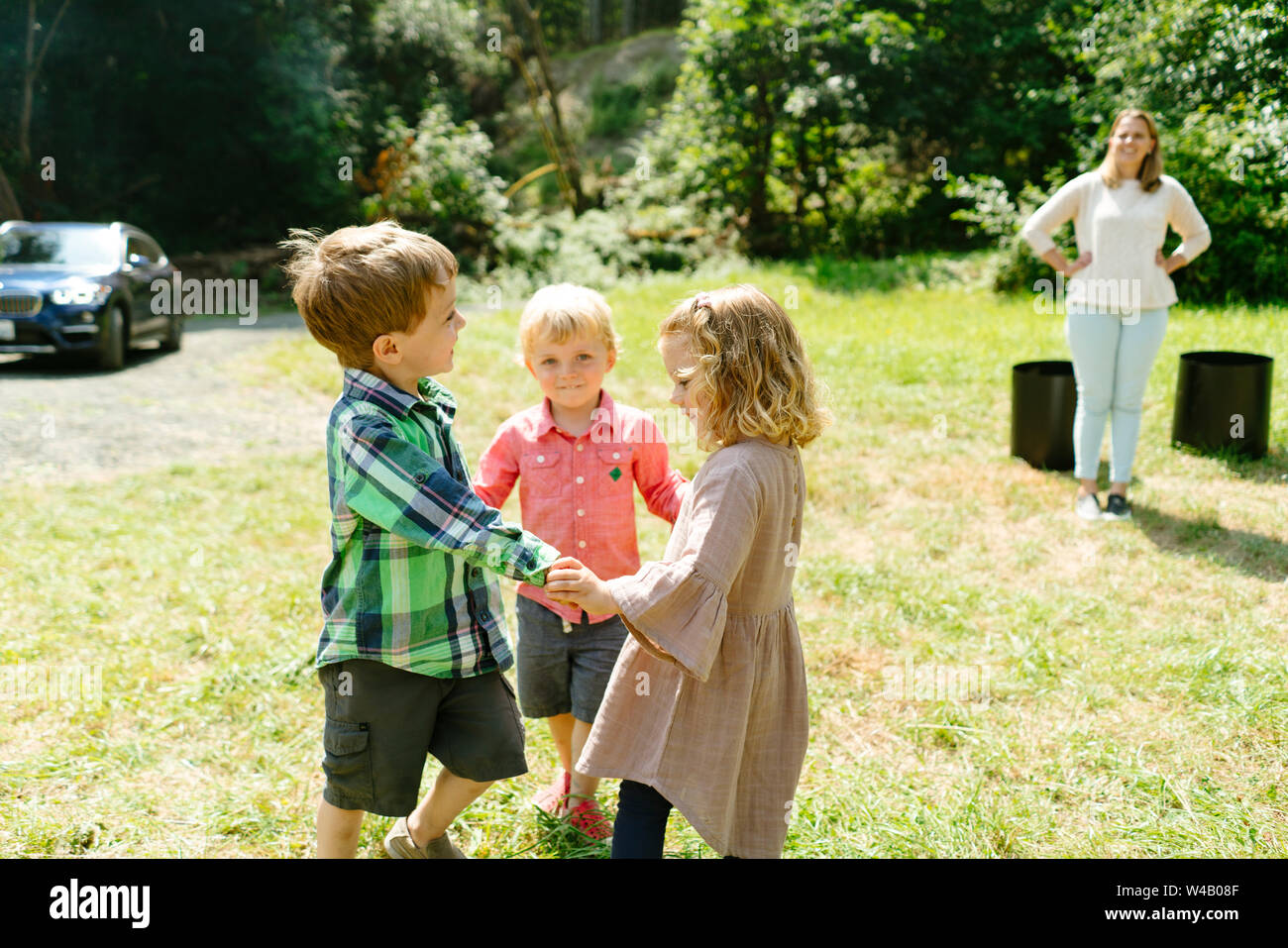 Portrait of three children holding hands and playing together Stock Photo