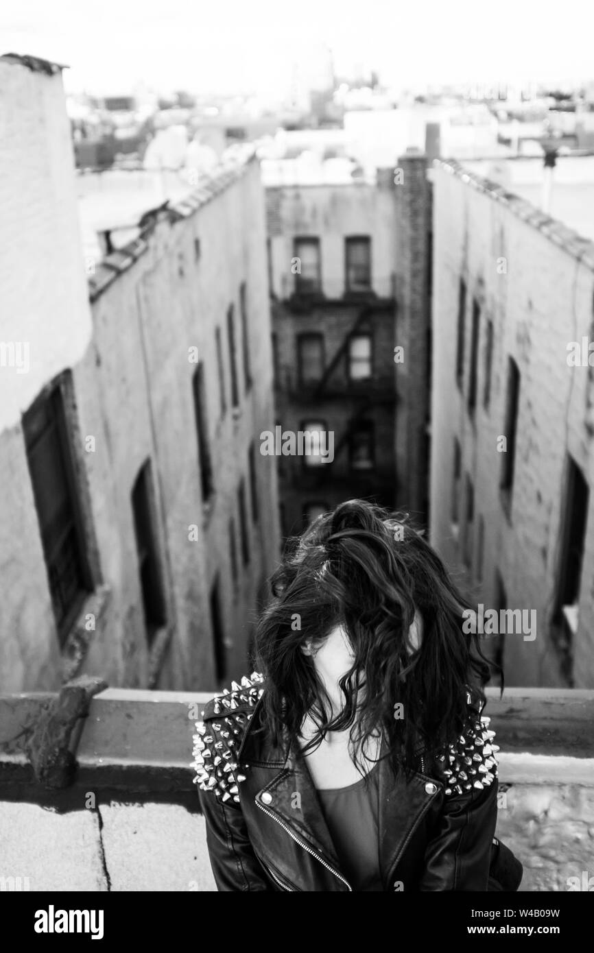 Hair covers womans face against Brooklyn buildings backdrop Stock Photo