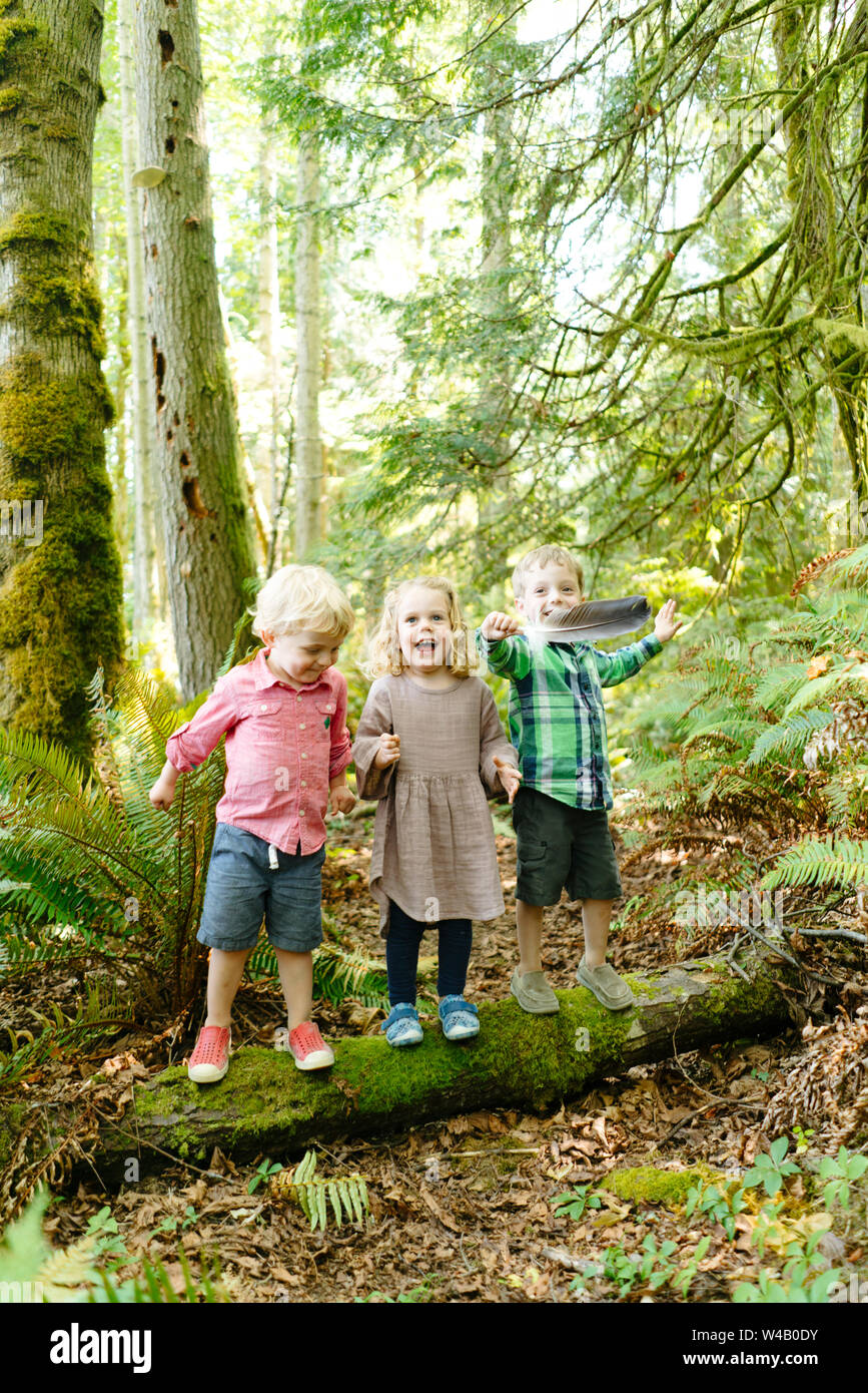 Straight on portrait of three kids playing together in the forest Stock Photo