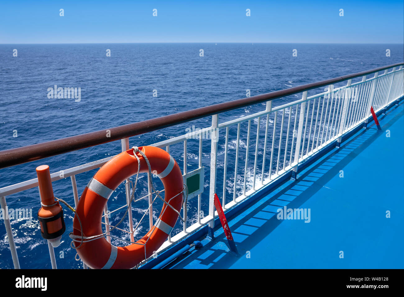 Ferry cruise railing in a blue ocean with round buoy and light beacon ...