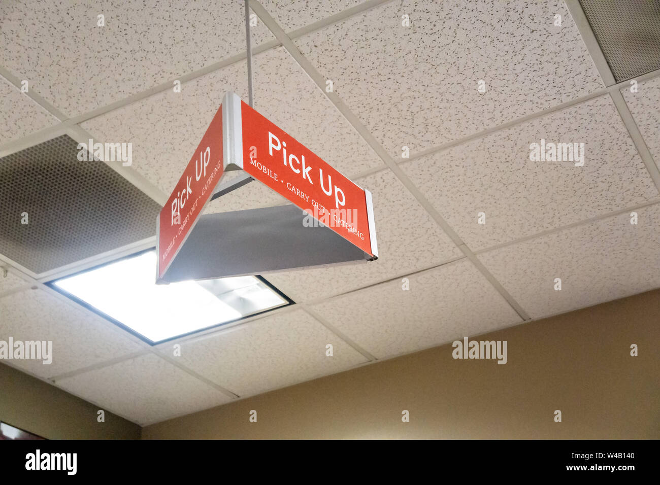 Atlanta, GA - July 26th 2019: Red pick up carry out sign on tile ceiling for mobile app orders at Chick-Fil-A. Jump the line and order ahead. Stock Photo