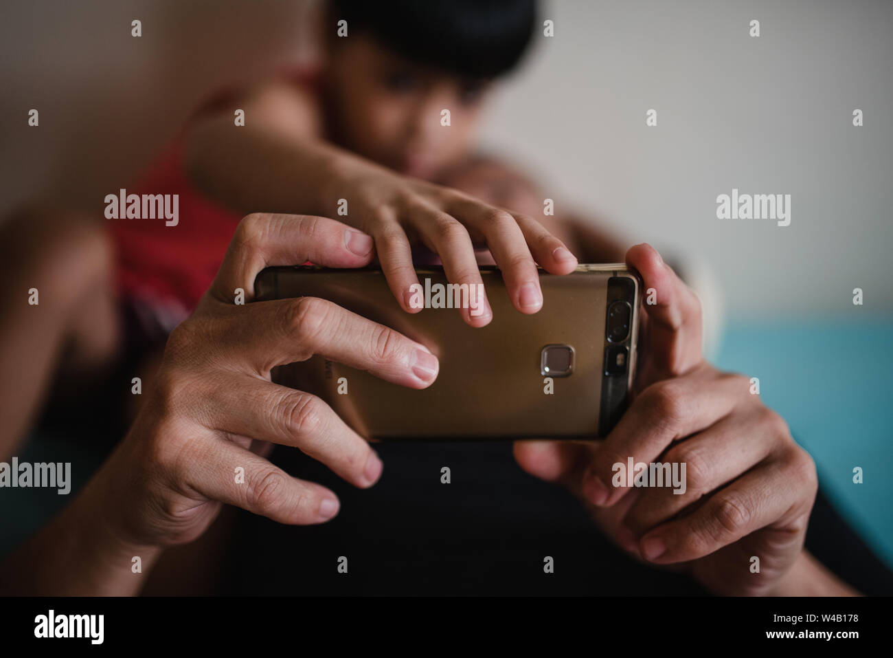 boy and father playing games on smartphone Stock Photo Alamy