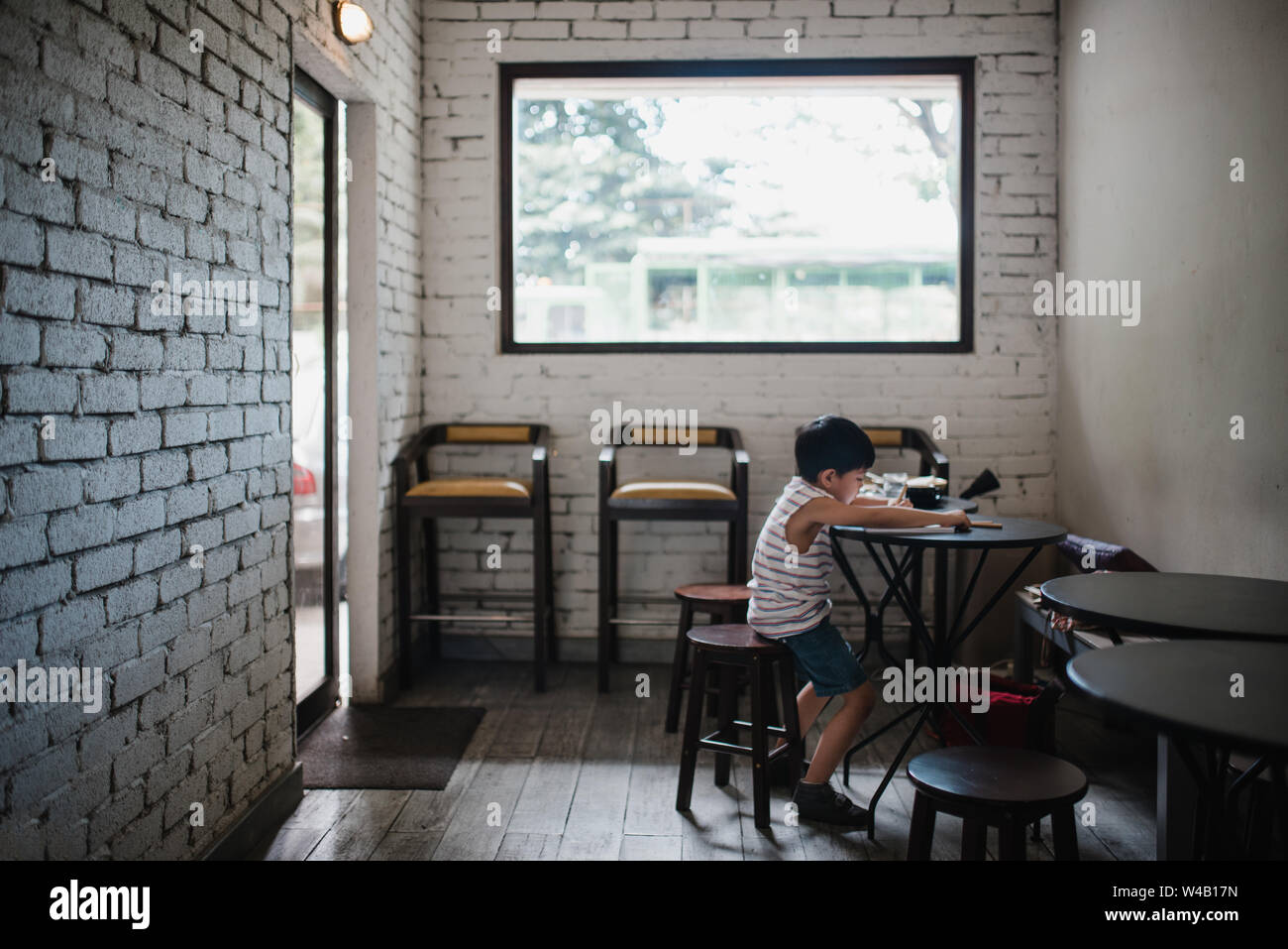 Boy sitting in a cafe Stock Photo
