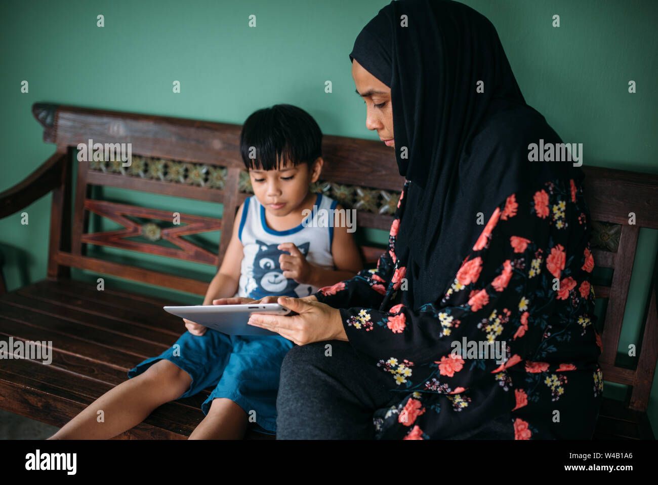 Asian mother and son playing games on smart tablet Stock Photo