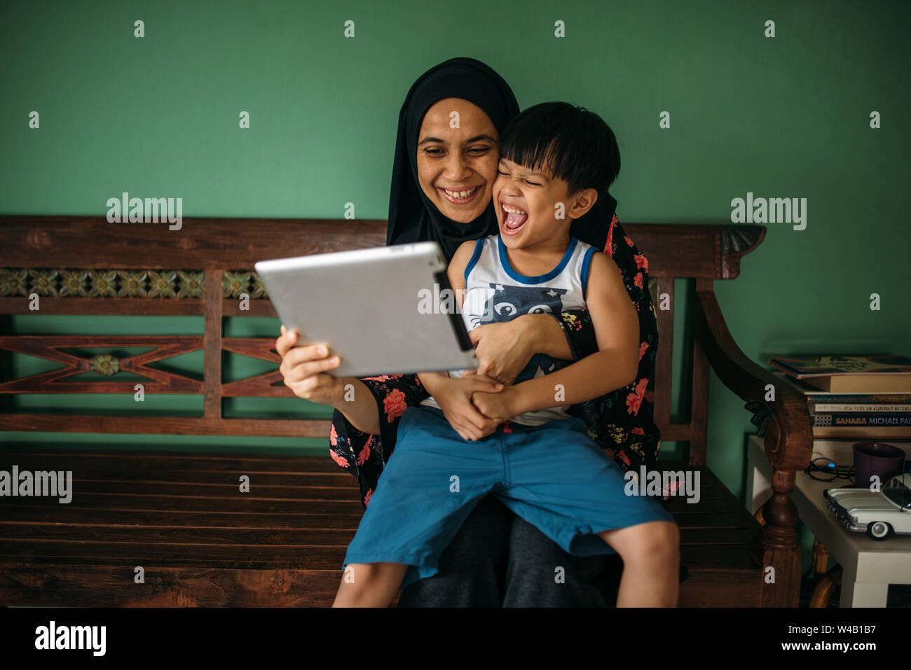 Asian mother with son playing games on tablet Stock Photo