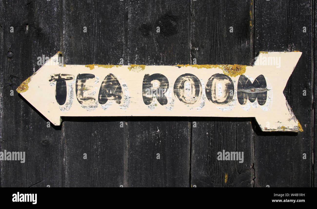 Rustic arrow with tea room sign painted on it pointing the direction of the  tea room on an old wooden barn Stock Photo - Alamy