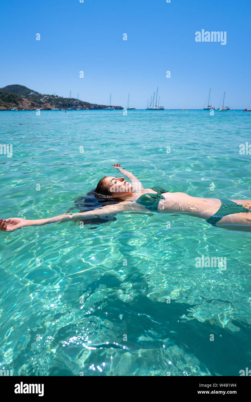 Ibiza bikini girl swimming clear water beach of Balearic Islands Stock Photo