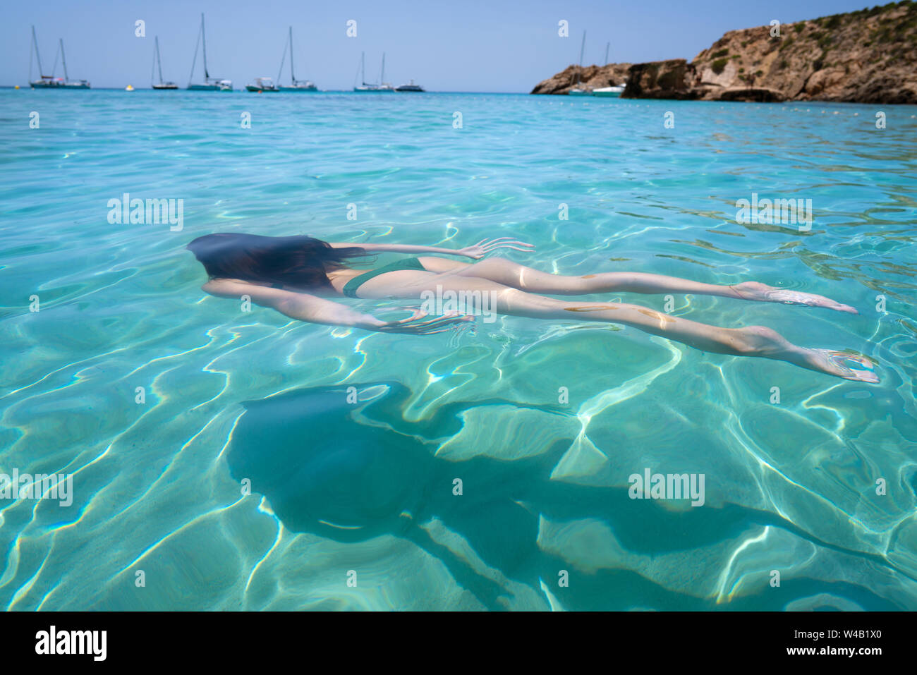 Ibiza bikini girl swimming clear water beach of Balearic Islands Stock Photo