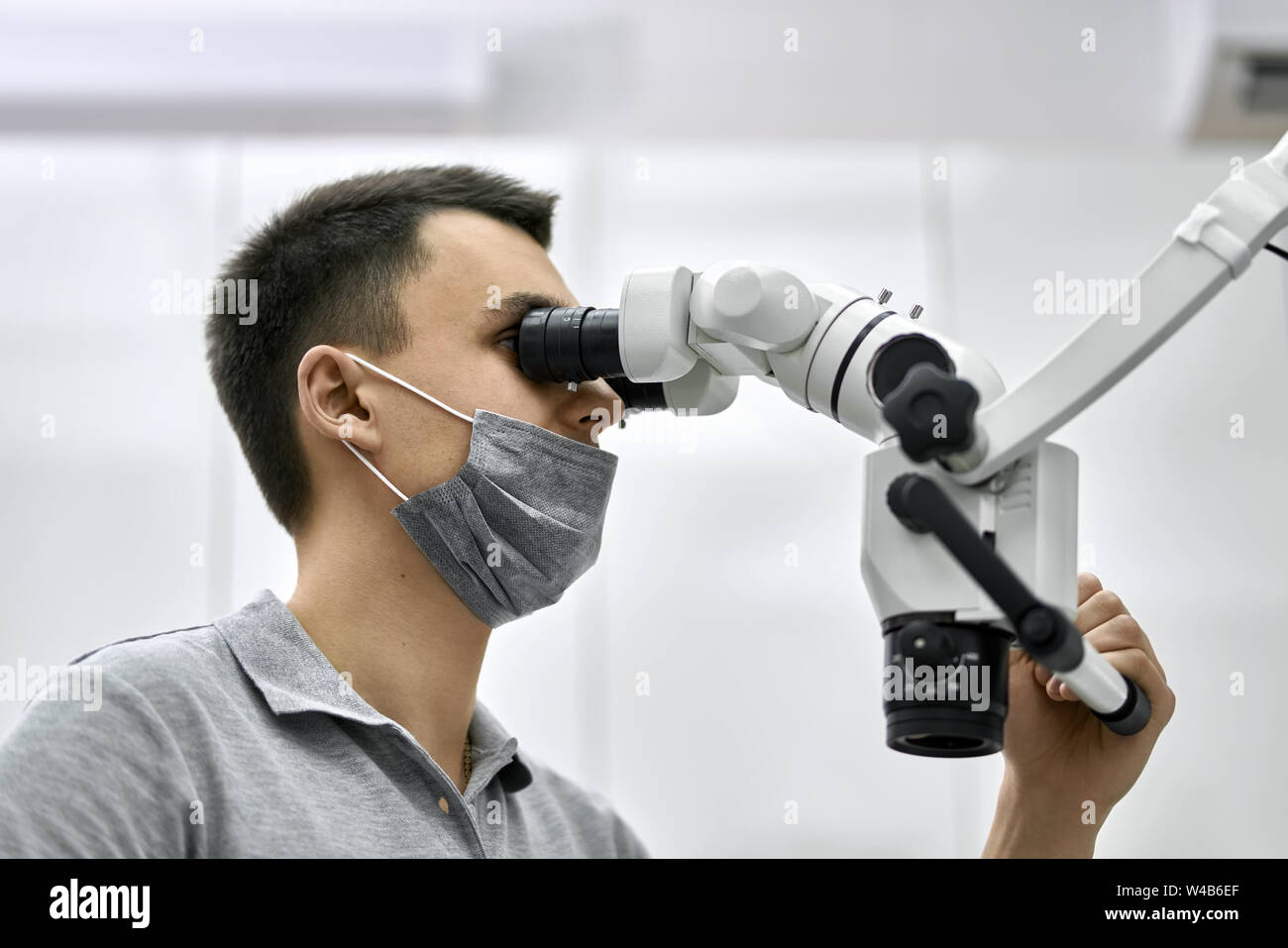 Dentist is using dental microscope during his work Stock Photo Alamy