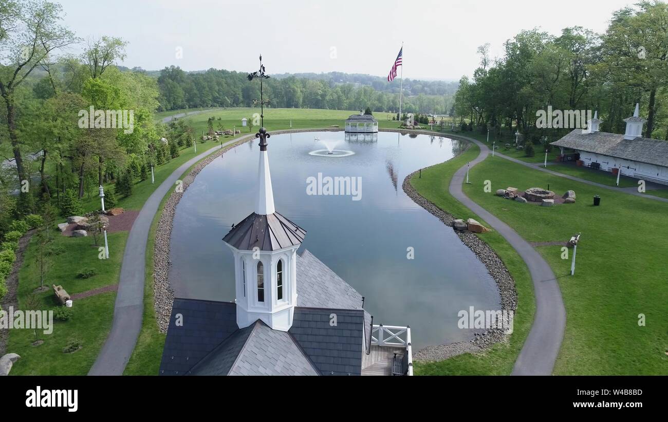 Aerial View of Old Restored Barns by a Pond on a Spring Day Stock Photo