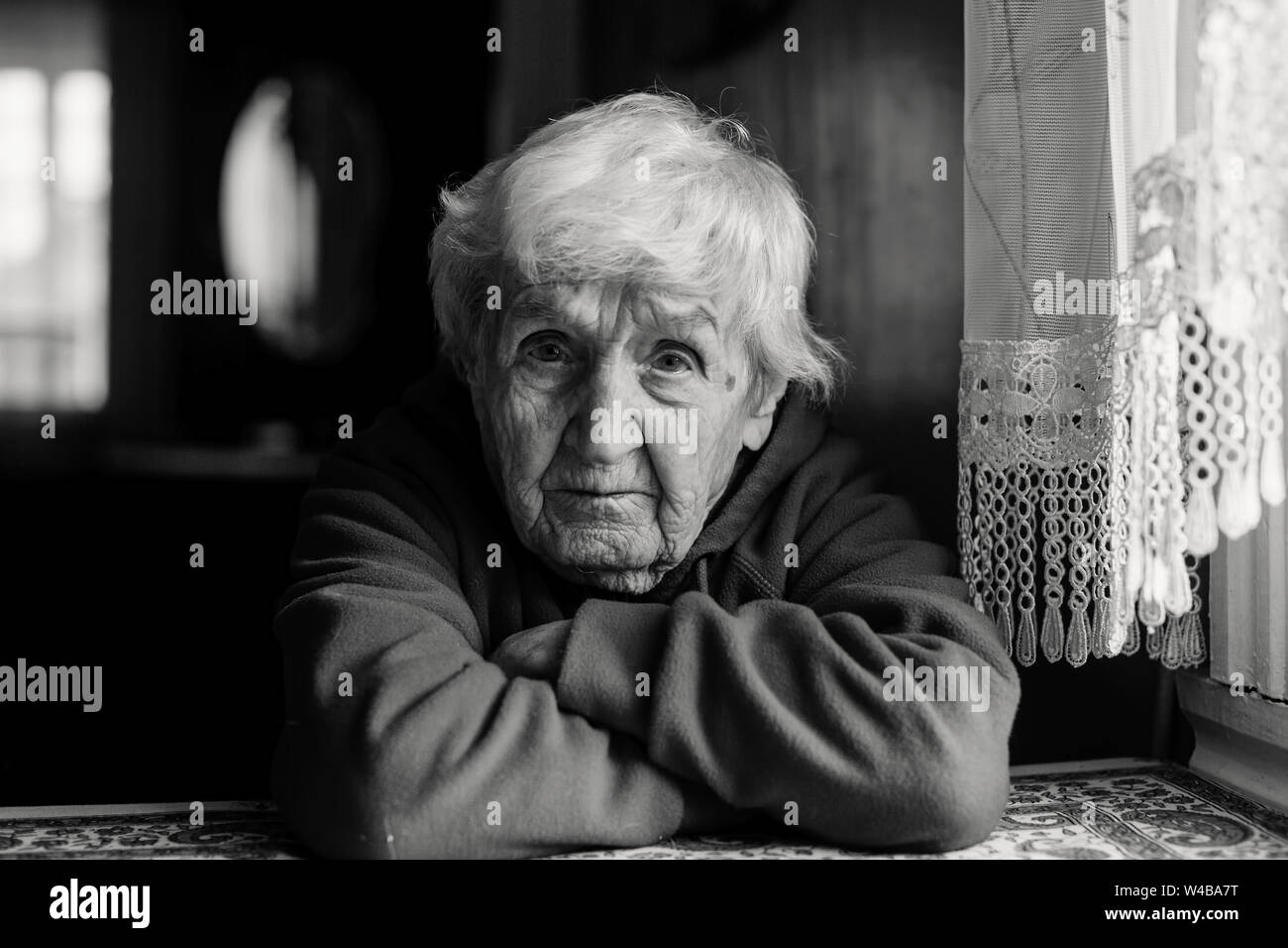 Portrait of a lonely sad old woman. Black and white photo. Stock Photo