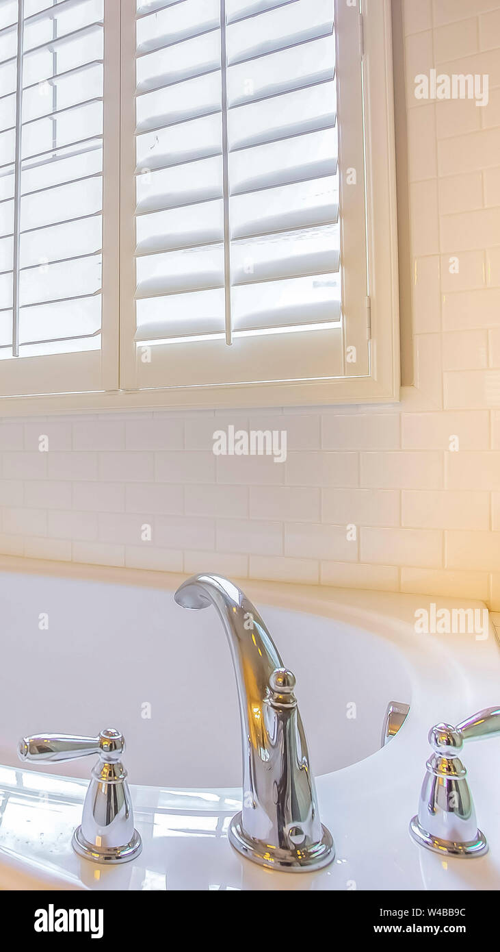 Vertical Frame Gleaming Built In Bathtub And Window With Blinds Inside A Bathroom A Shiny Steel Towel Rod Is Installed On The White Wall Of The Room Stock Photo Alamy
