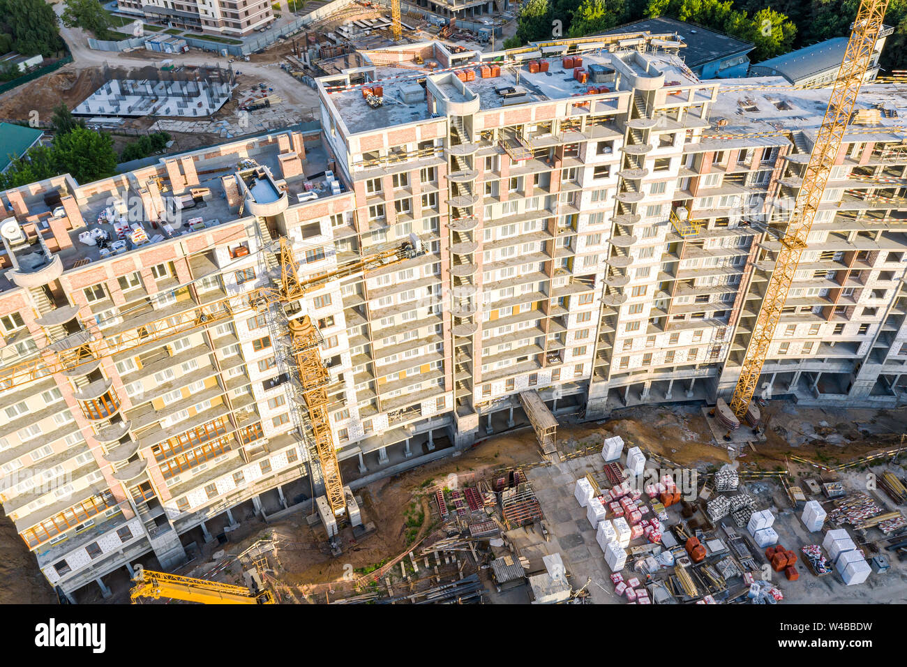 construction of new multistory apartment building. yellow tower cranes ...