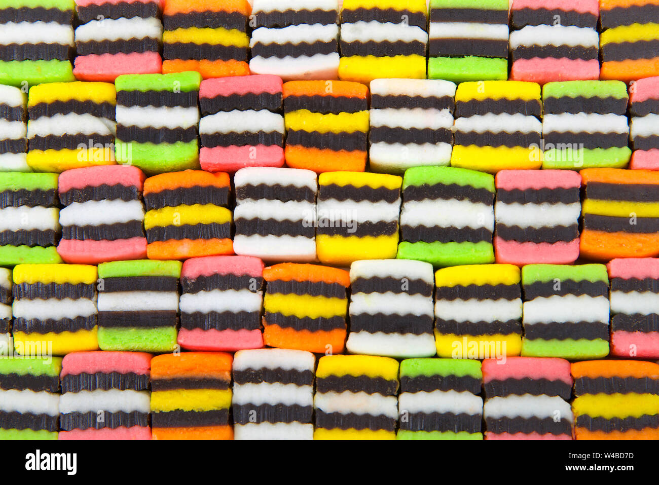 Background of bright colorful licorice candy squares alternating colors. Stock Photo