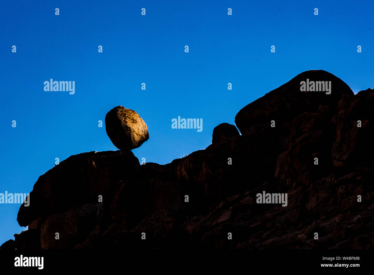 A boulder teeters impossibly on the side of a mohtain in South Africa Stock Photo