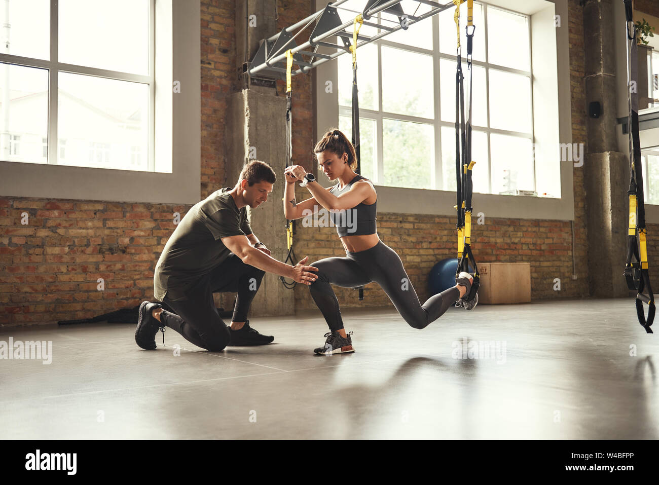 Making perfect body. Young athletic woman exercising with suspension straps  in the gym. Professional sport. TRX Training. Workout Stock Photo - Alamy