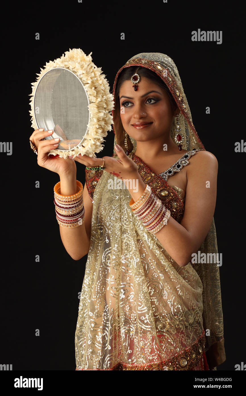 Woman looking through sieve during karwa chauth Stock Photo Alamy