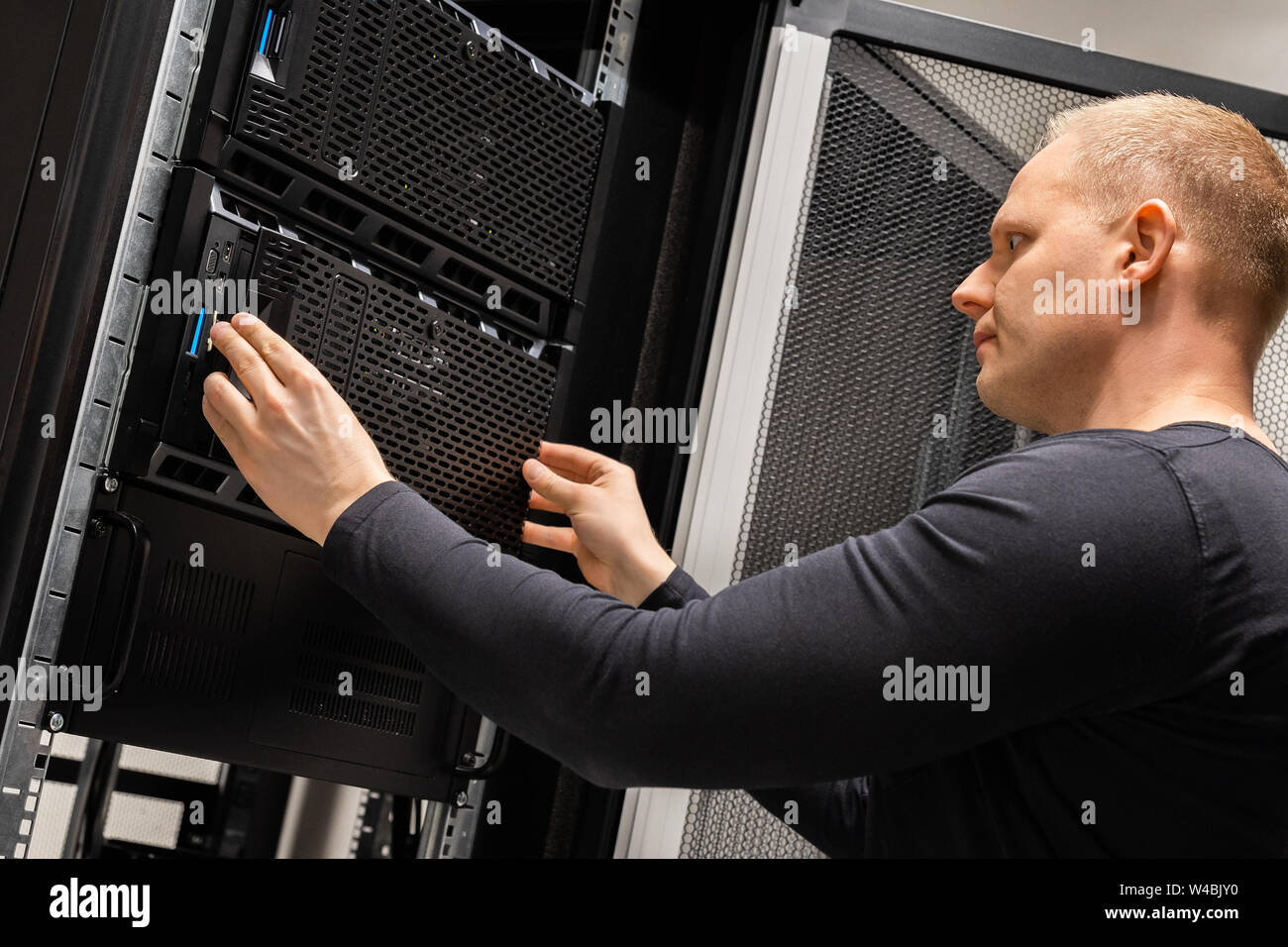 Focused Male Technician Working With Servers In Datacenter Stock Photo