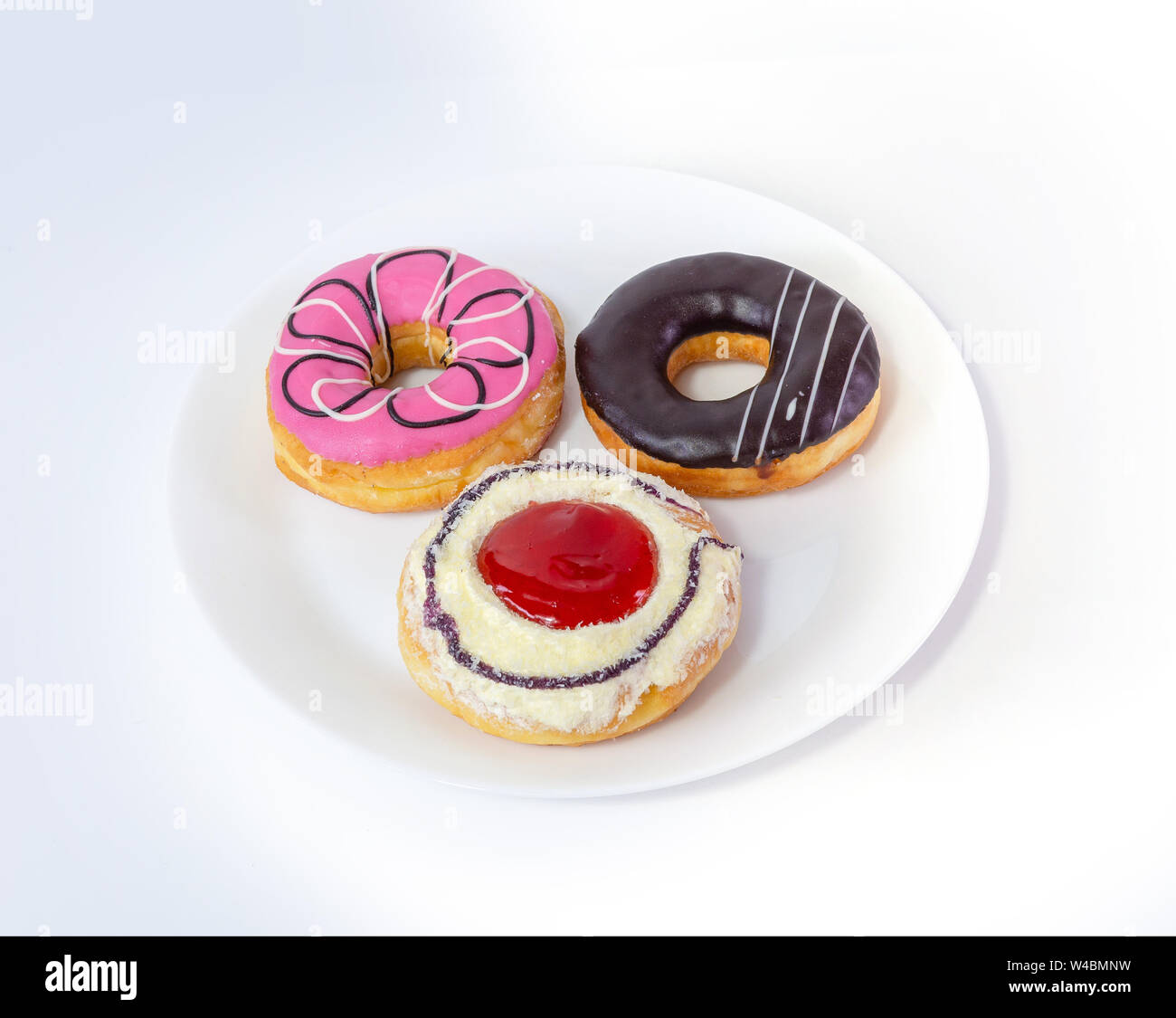 Three sweet donuts on plate on white background Stock Photo