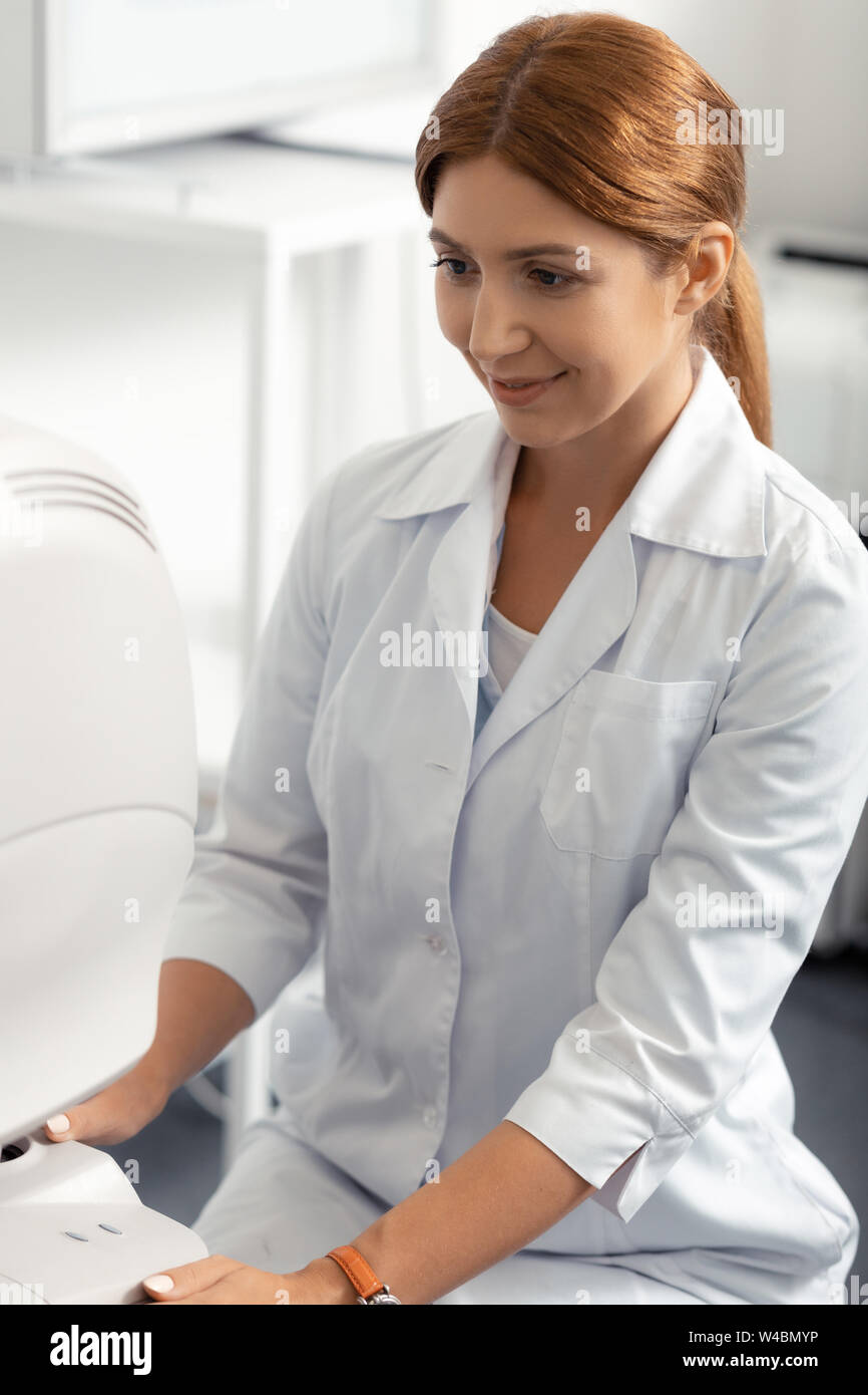 Looking at screen. Darkeyed eye doctor looking at the screen while