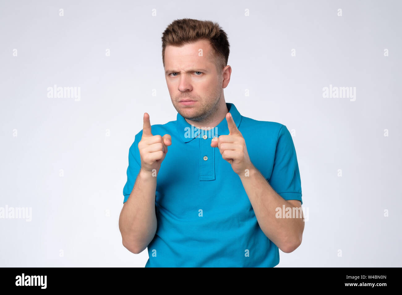 Youn caucasian man frowning accusing his coworker. Giving advice concept Stock Photo