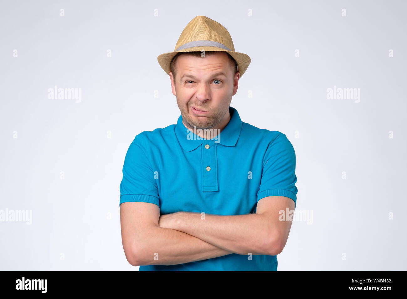 Displeased discontent man frowns face, dislikes something, looks with disgusting expression. Stock Photo