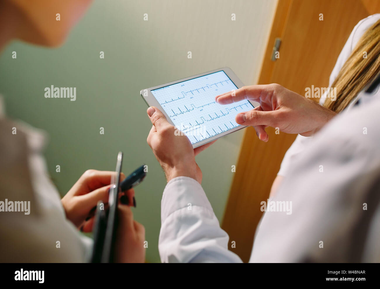 Doctors discussing patient's cardiogram on the tablet Stock Photo