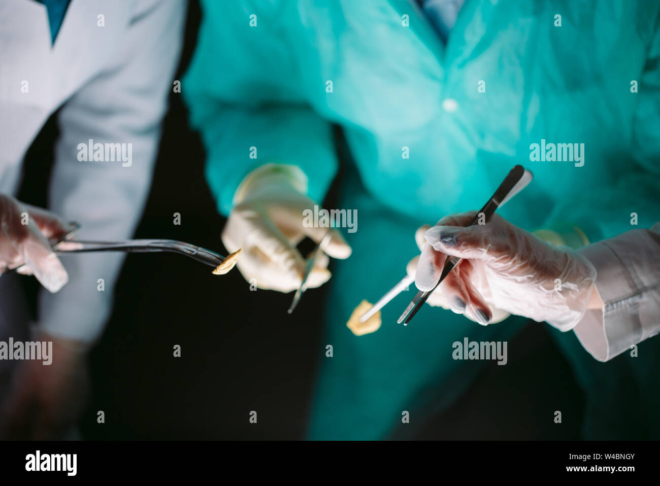 Hands closeup of surgeons holding medical instruments. The surgeon