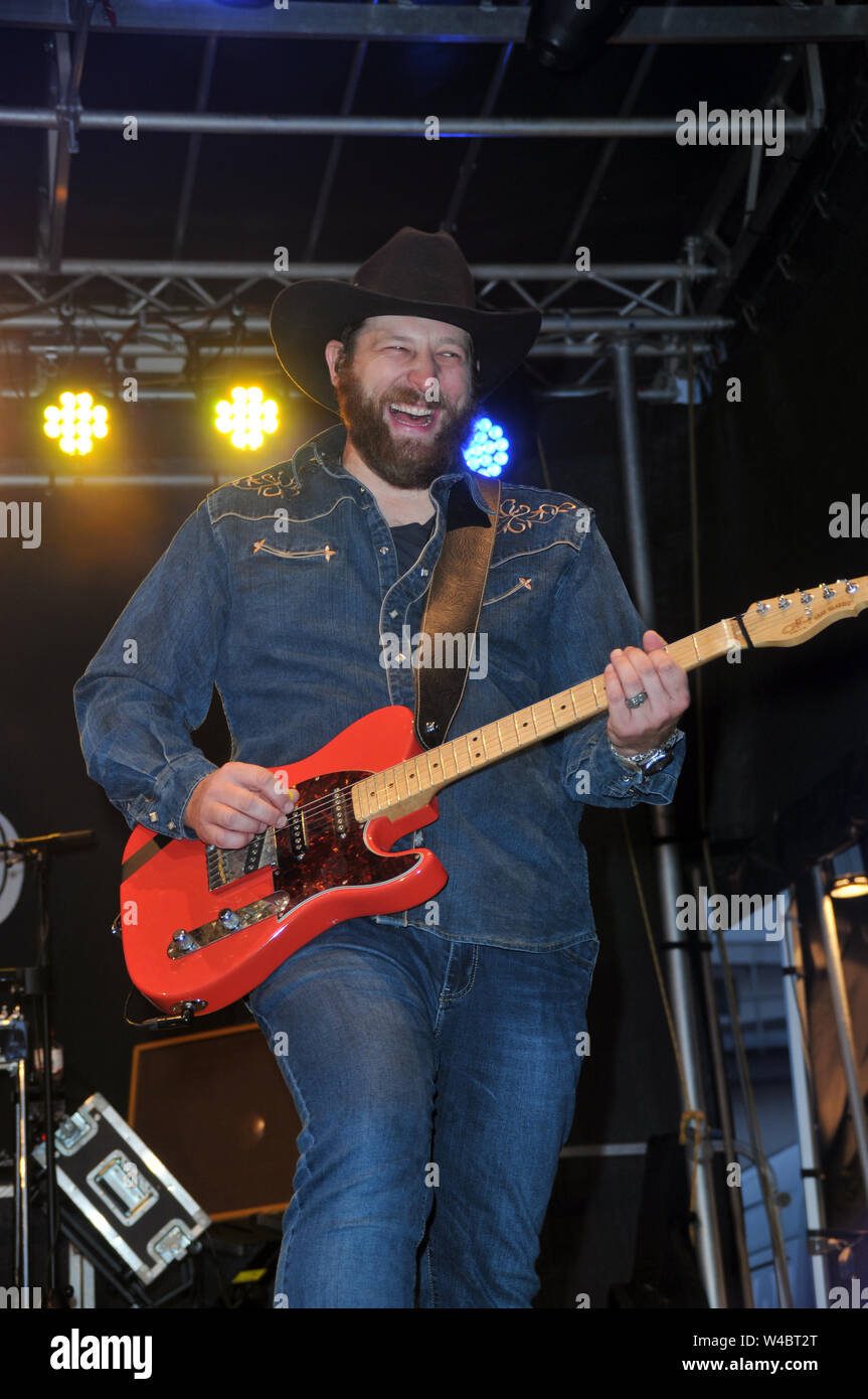 16 July 2019, Schleswig-Holstein, Heiligenhafen: TRUCK STOP - The Country Band from Waterkant on 16 July 2019 in Heiligenhafen at the Heiligenhafener Hafenfesttage (For the 44th time from 11 July to 21 July 2019) open air stage appearance dierkt at the harbour basin. From 20 - 22 o'clock there was Country Rock and songs from the brand new album "Ein Stückchen Ewigkeit" for over two thousand guests of the event. Schleswig-Holstein, Germany, Europe. - Guitarist - Chris Kaufmann. Photo: Holger Kasnitz/dpa Stock Photo