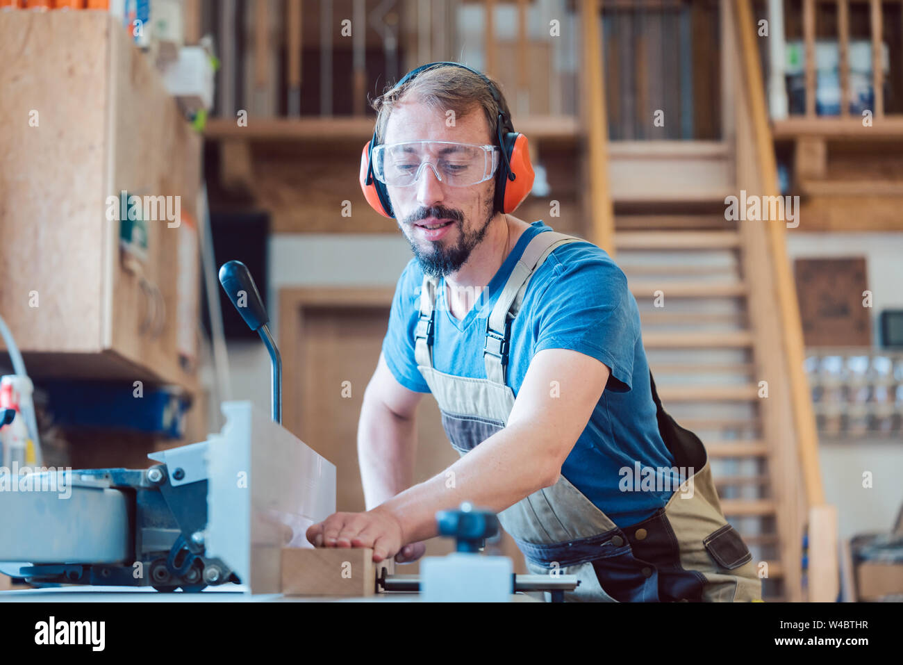 Busy carpenter at the circular cutter working with wood Stock Photo