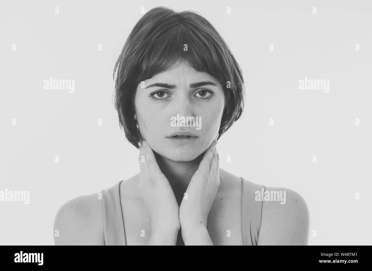 Black and white portrait of young sad woman, serious and concerned, looking worried and thoughtful. Feeling sorrow and depression. Isolated in neutral Stock Photo