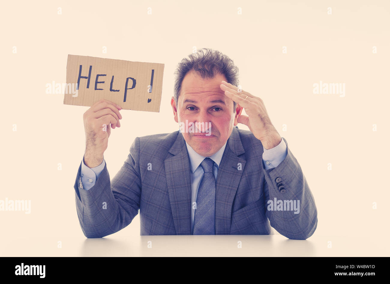Depressed middle aged caucasian businessman desperate and tired holding a help sign looking frustrated, upset and unhappy. In business and stress at w Stock Photo
