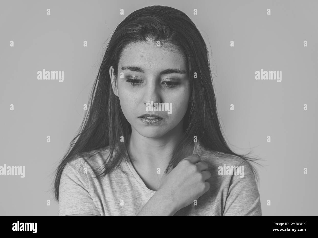 Black and white portrait of a young sad woman, serious and concerned, looking worried and thoughtful. Feeling sorrow and depression. With copy space. Stock Photo