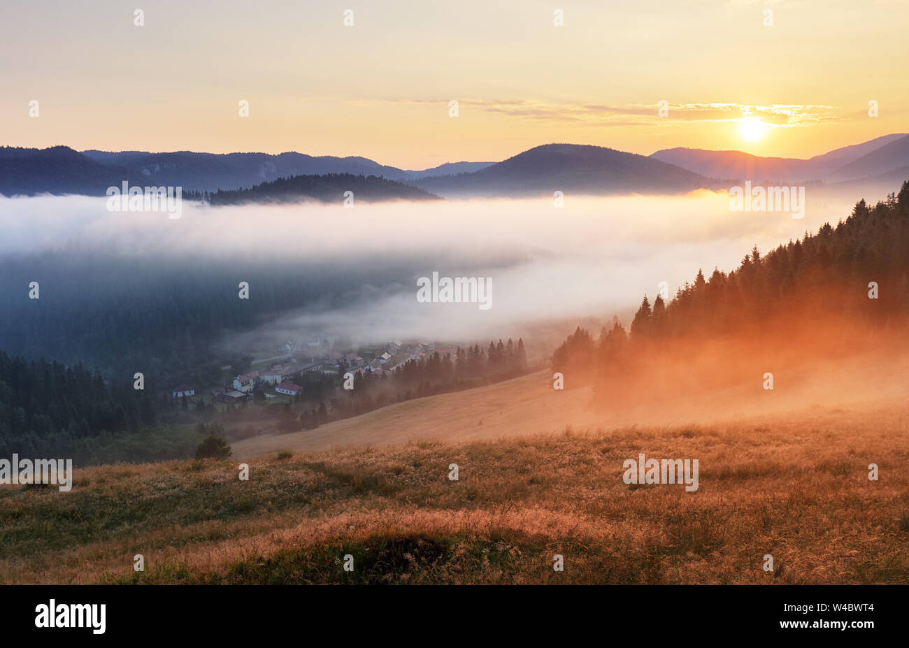 Misty sunrise with sun and forest, Mlynky, Slovakia Stock Photo