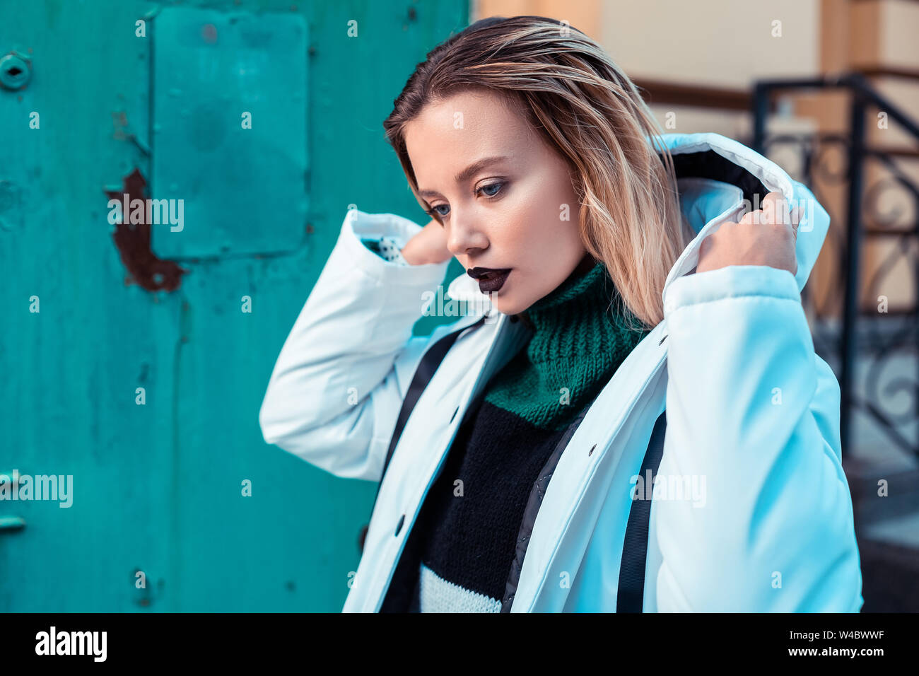 Blonde model with dark lipstick posing in winter jacket Stock Photo