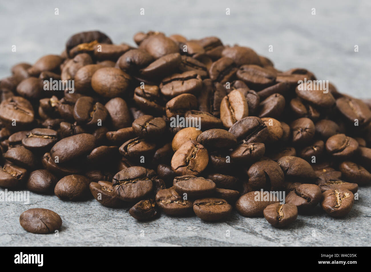 Roasted coffee beans pile on grey stone background Stock Photo - Alamy