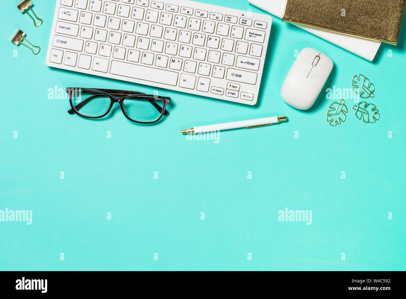 Office workplace with keyboard, notepad, glasses and pen Stock Photo