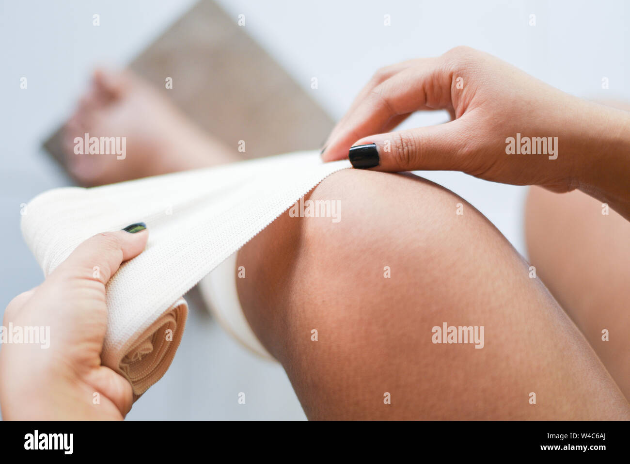wound bandaging an injured knee sprains / first aid leg injury health care and medicine concept Stock Photo